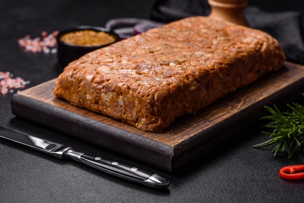 Lekkere vleesbrawn of roll op een houten snijplank met specerijen en kruiden