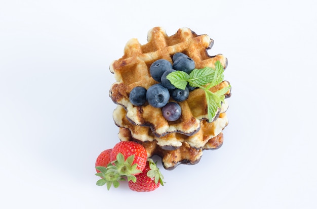 Lekkere wafels met fruit op witte achtergrond