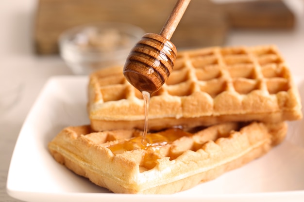 Lekkere wafels met honing op plaat, close-up