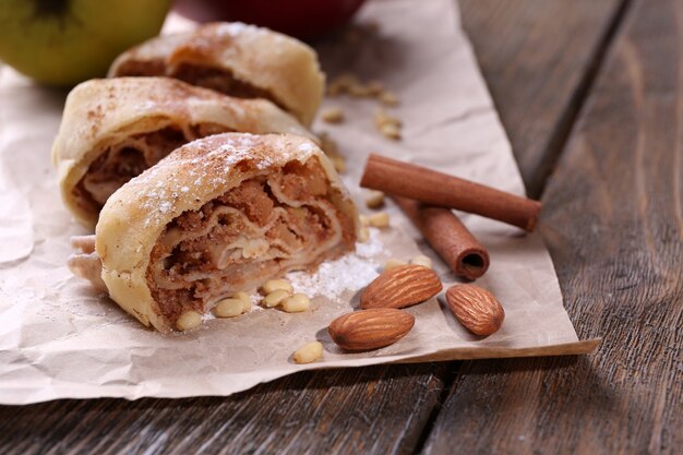 Lekkere zelfgemaakte apfelstrudel op papieren servet, op houten achtergrond