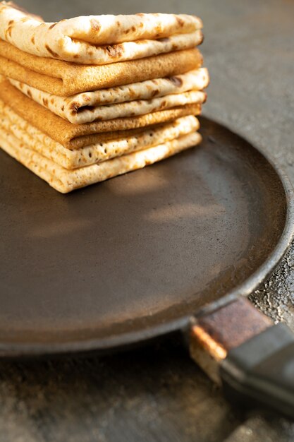 Lekkere zelfgemaakte rustieke pannenkoek in een koekenpan op houten tafel. Maslenitsa eten.