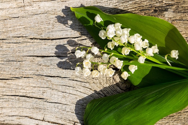 Lelietje-van-dalen bloemen op houten achtergrond met kopie ruimte. Bovenaanzicht