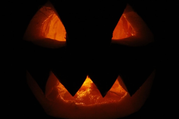 Lelijk spook gezicht gloeit op Halloween in de duisternis