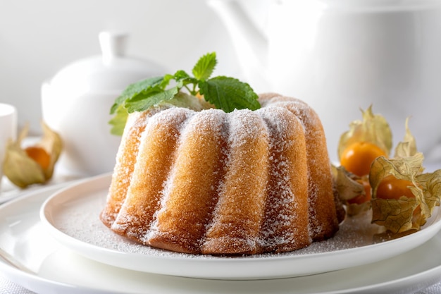 Foto biscotto al limone su un piatto bianco su sfondo bianco con bacche di physalis