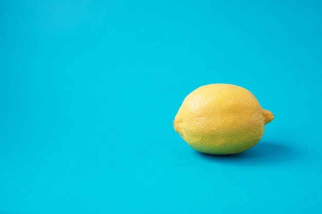Photo lemon on a blue backgroundvitamins beautiful colors style minimalism vegetarian raw food