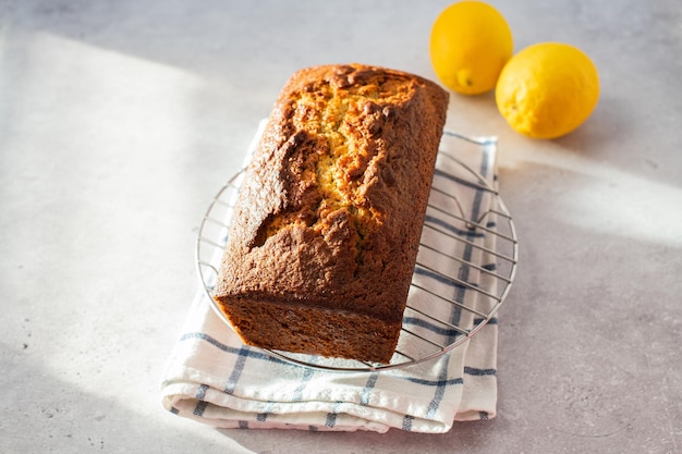 Lemon cake on a cooling rack on a gray background