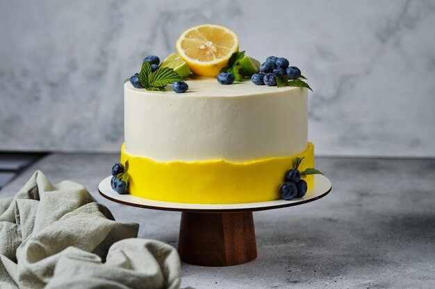 Lemon cake garnished with lemon, lime and fresh berries. Personalized dessert for your birthday.