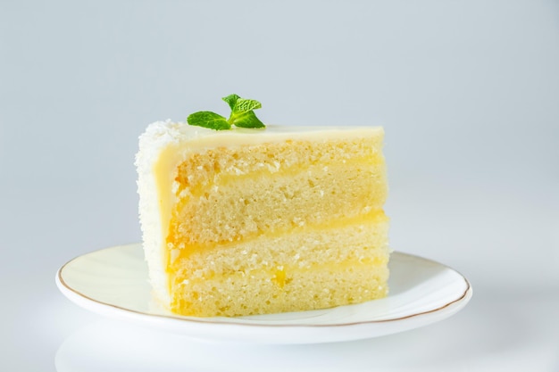 Lemon cake with coconut flakes. A piece of delicate vanilla dessert with cream.