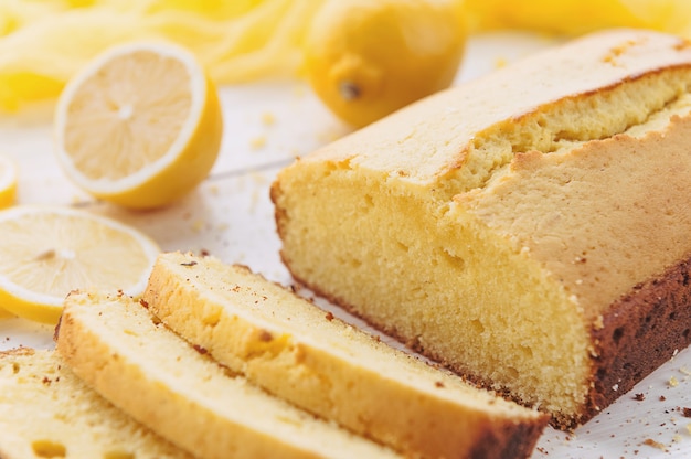 Lemon cake with fruits on white wooden surface