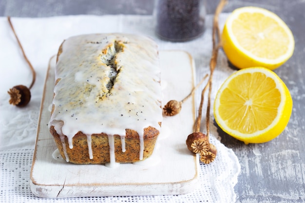 Photo lemon cake with poppy seeds, covered with glaze on a light background. selective focus.