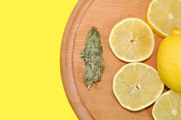 Photo lemon and cannabis on a wooden tray on a white background medical cannabis cannabis lemon flavor