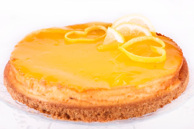 Photo lemon cheesecake on white background decorated with lemon zest close up