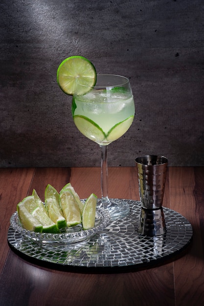 Lemon cocktail on a mirror tray concrete background, copy space, 45 degree view.