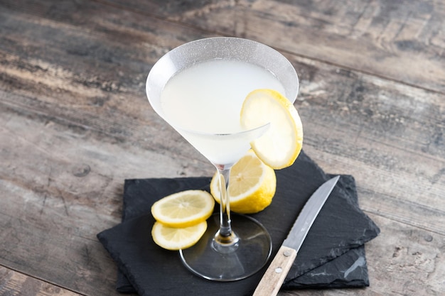 Lemon drop martini cocktail on gray stone and black background