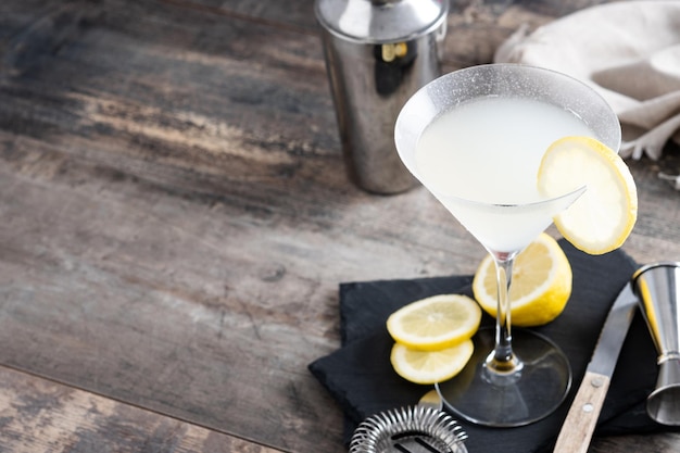 Lemon drop martini cocktail on gray stone and black background