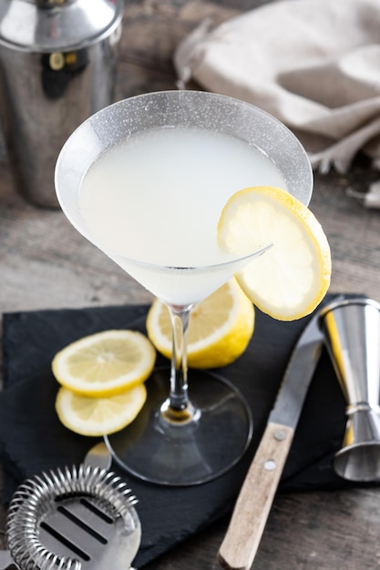 Lemon drop martini cocktail on gray stone and black background