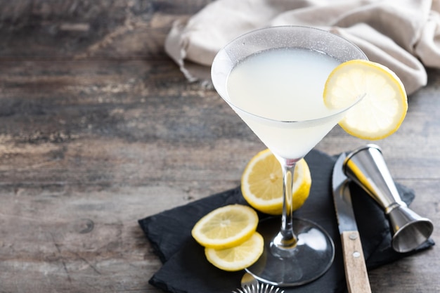 Cocktail martini goccia di limone su pietra grigia e sfondo nero