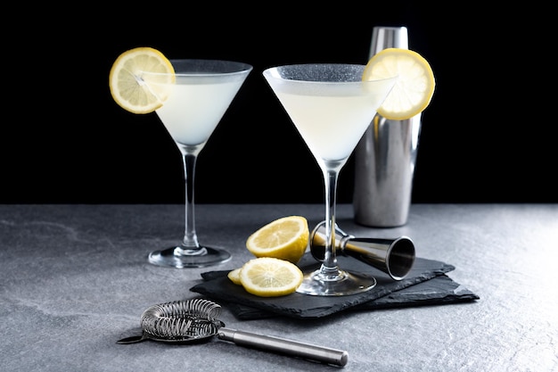 Lemon drop martini cocktail op grijze steen en zwarte achtergrond