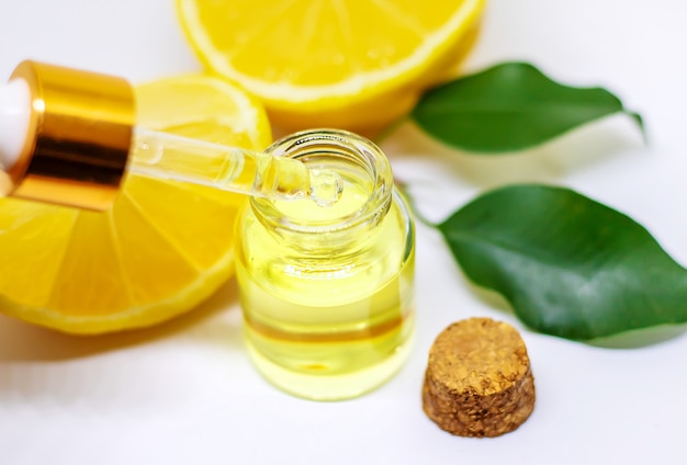 Эфирное масло лимона в бутылке и лимоны