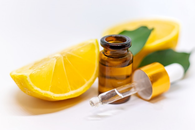 Lemon essential oil in a bottle and lemons