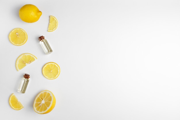 Lemon essential oil. Lemon slices on white background.
