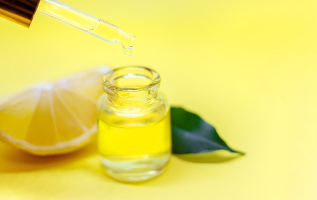 Olio essenziale di limone su sfondo giallo. messa a fuoco selettiva.