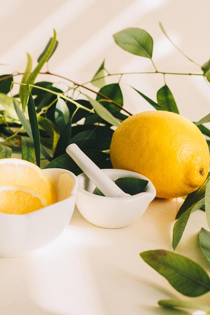 Lemon and eucalyptus leaves in small white ceramic mortar