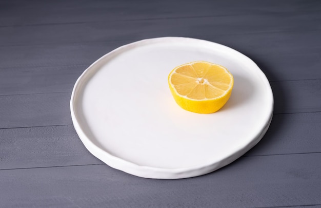 Lemon on flat white plate handmade on a gray wooden table looks\
like fried eggs