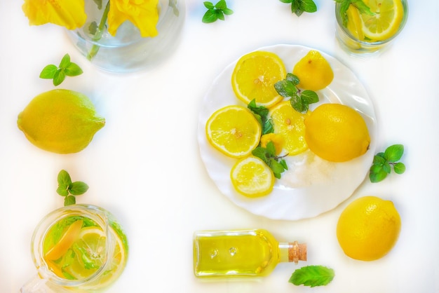 Limone frutta foglie di menta rametti bevanda al limone in una brocca bottiglie di olio di limone sano fruts drink