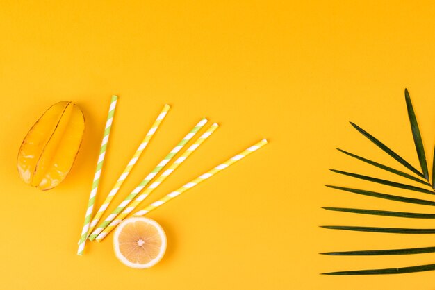 lemon and a green leaf on a colored surface