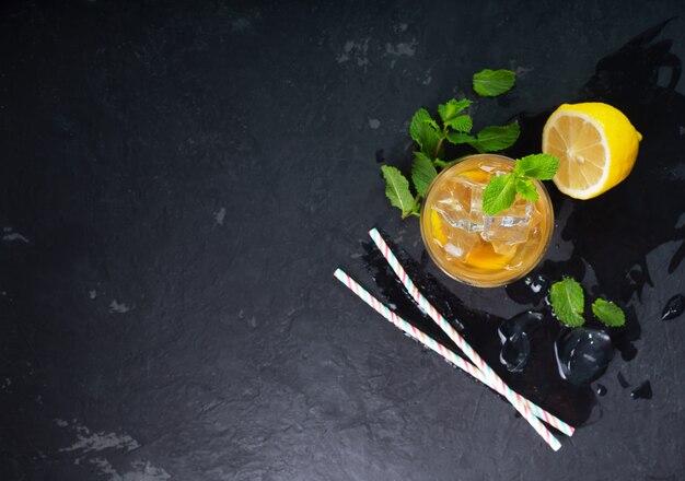 Lemon ice tea on dark background with mint and ice