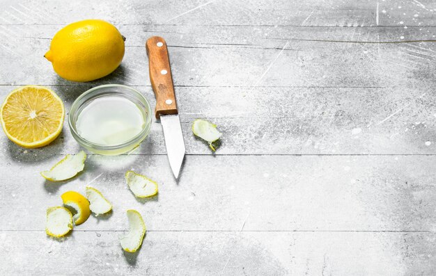 Lemon juice bowl with the zest of a lemon and a knife