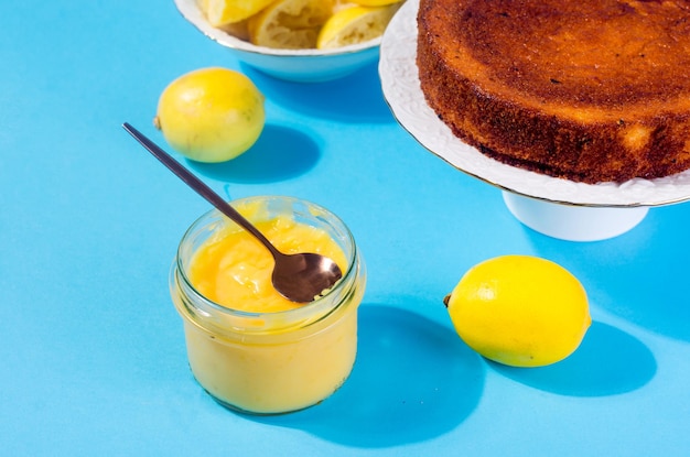 Lemon Kurd in a glass jar on blue background