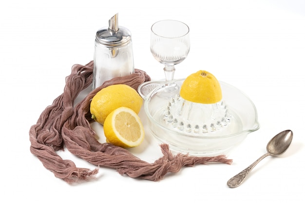 Spremiagrumi limone e limone in vetro su uno sfondo bianco