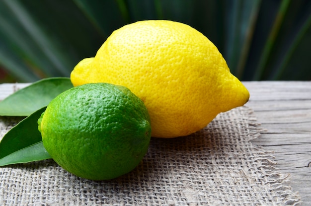 레몬과 라임 오래 된 나무 배경에 신선한 익은 유기농 과일. 건강한 식사 또는 아로마 테라피 개념.