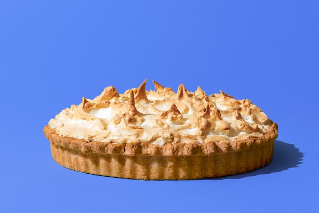 Lemon meringue pie isolated on a blue background Homemade lemon tart