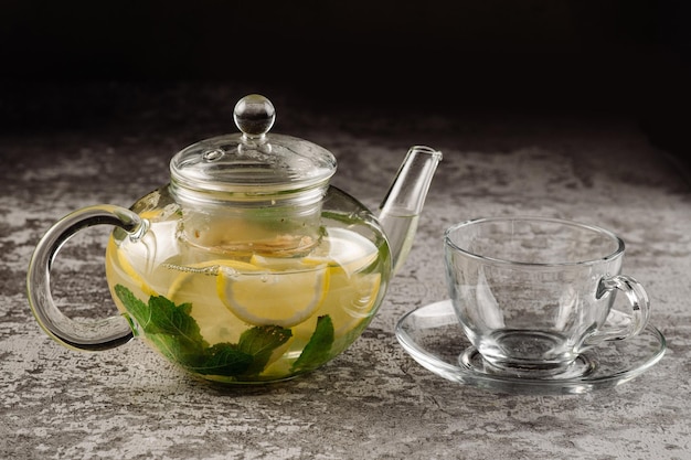 Lemon and mint tea in glass kettle