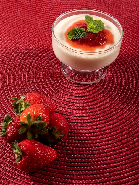 Lemon mousse in crystal bowl with strawberry jelly topping and mint