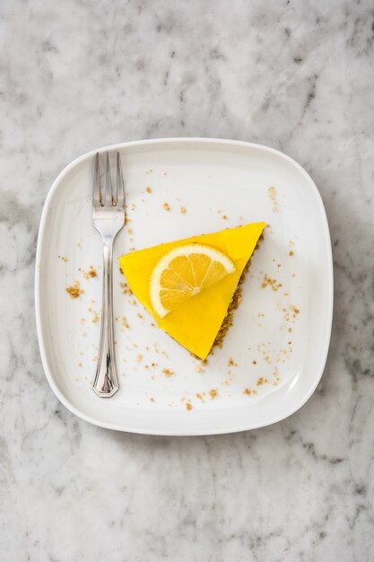 Lemon pie slice on white marble top view