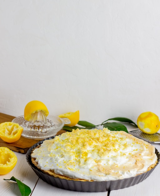 Lemon pie with meringue on a wooden background.