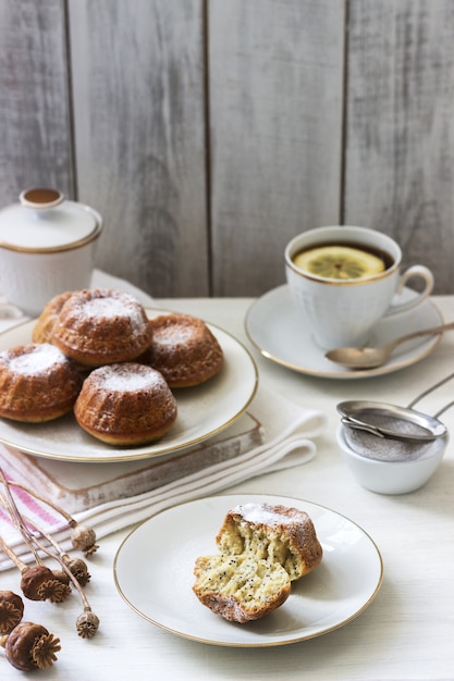 Foto muffin del biscotto del papavero del limone per tè su una superficie leggera