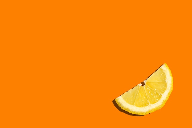 Lemon slice on orange with copy space top view