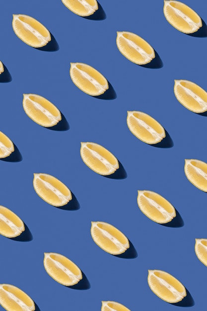 Lemon slices pattern on pastel blue background. Minimal sunlit flat lay.