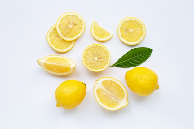Лимон и ломтики с листьями, изолированные на белом.