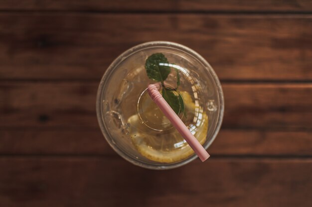 Lemon soda in plastic glass on wooden table in the cafe