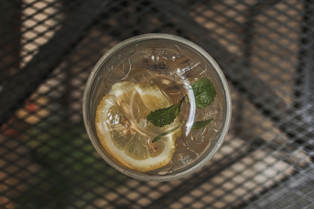 Lemon soda in plastic glass on wooden table in the cafe