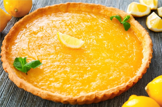 Lemon tart with mint on wooden table