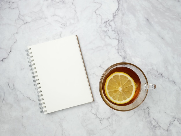 Lemon tea and book on marble texture background