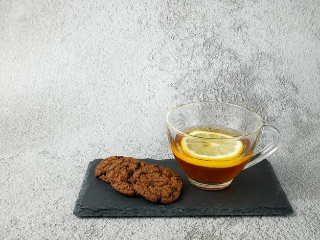 Lemon tea and cookies on stone texture background