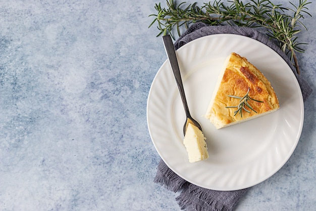 Cheesecake al limone e vaniglia con fette di rosmarino, menta e limone.